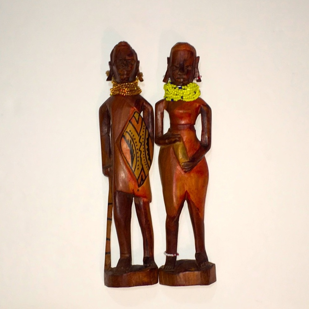 A pair of Hand Carved Solid Wood statues, man and woman.  Nice beading.